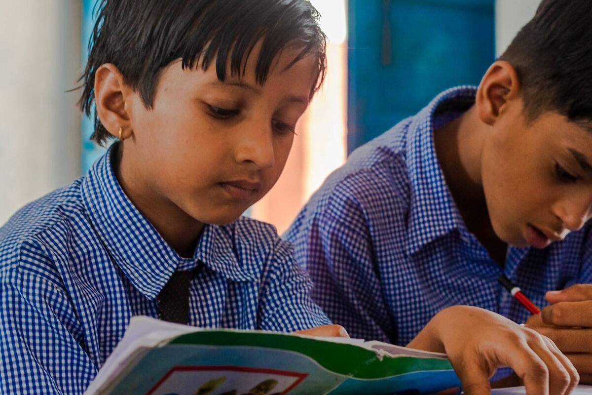 Two schoolboys reading from open books
